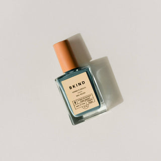 A bottle of BKIND nail polish in a cloudy blue shade with a dropper, labeled as vegan and 21-free.